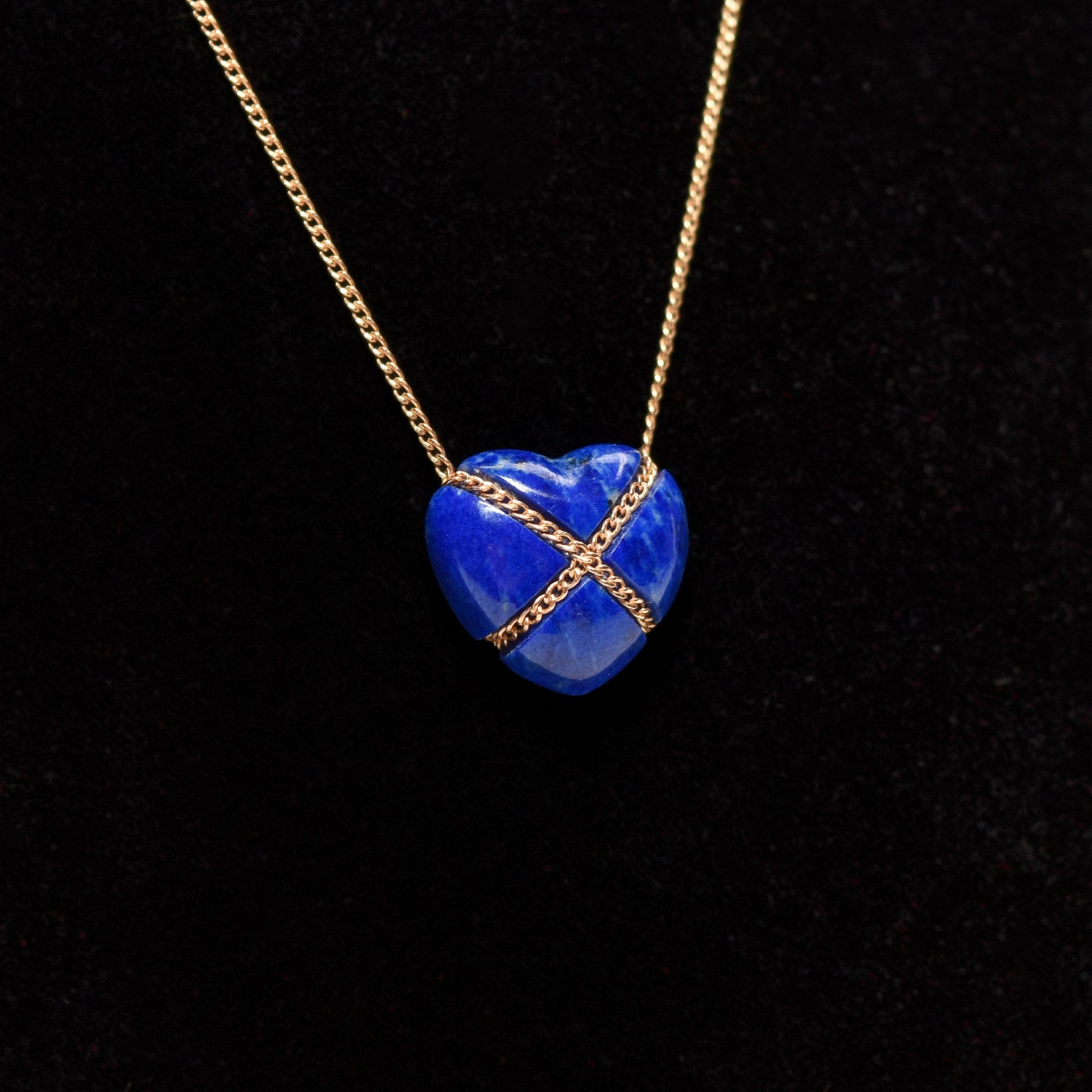 14K gold Tiffany & Co. lapis lazuli heart cross pendant necklace on a minimalist 18-inch chain against a black background.