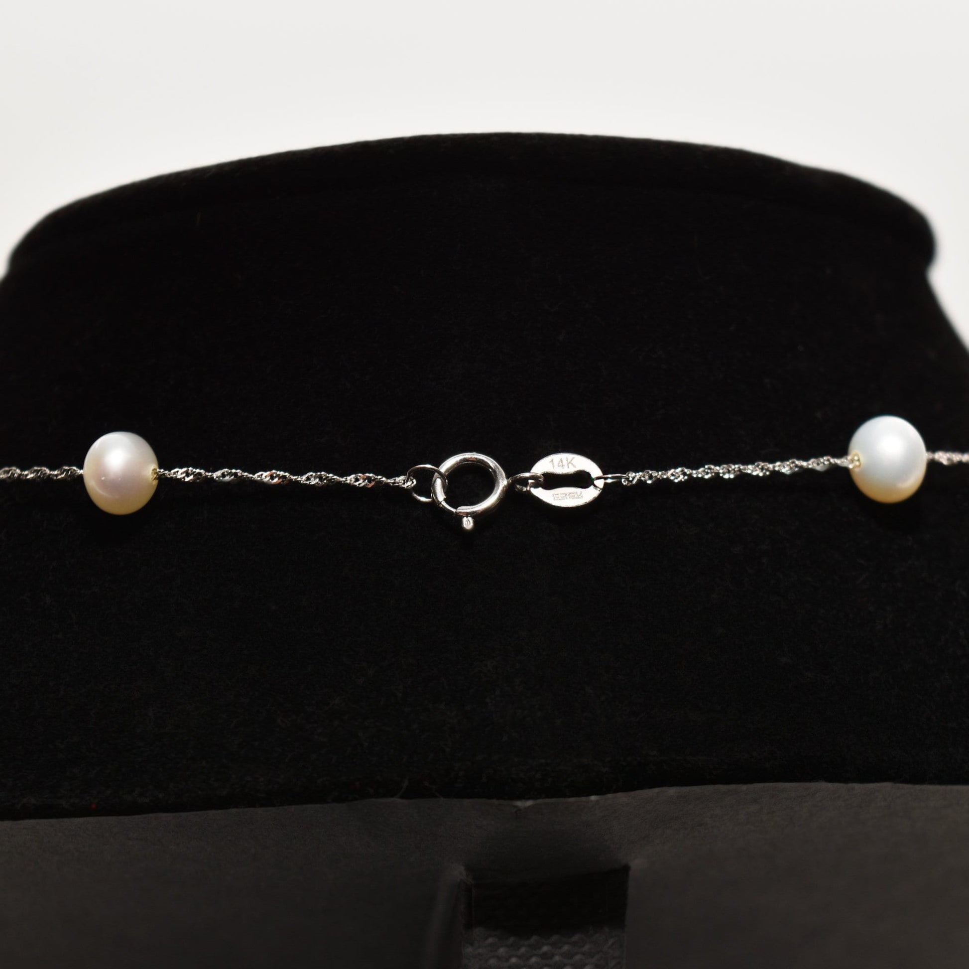 White pearl choker necklace in 14k white gold with pearl station design on black velvet display, 17.75 inches long