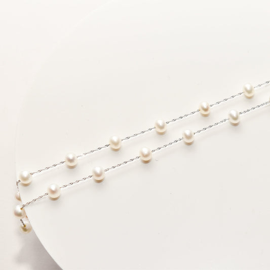 Elegant white pearl choker necklace in 14K white gold on a white background, featuring spaced pearls along a 17.75-inch chain.