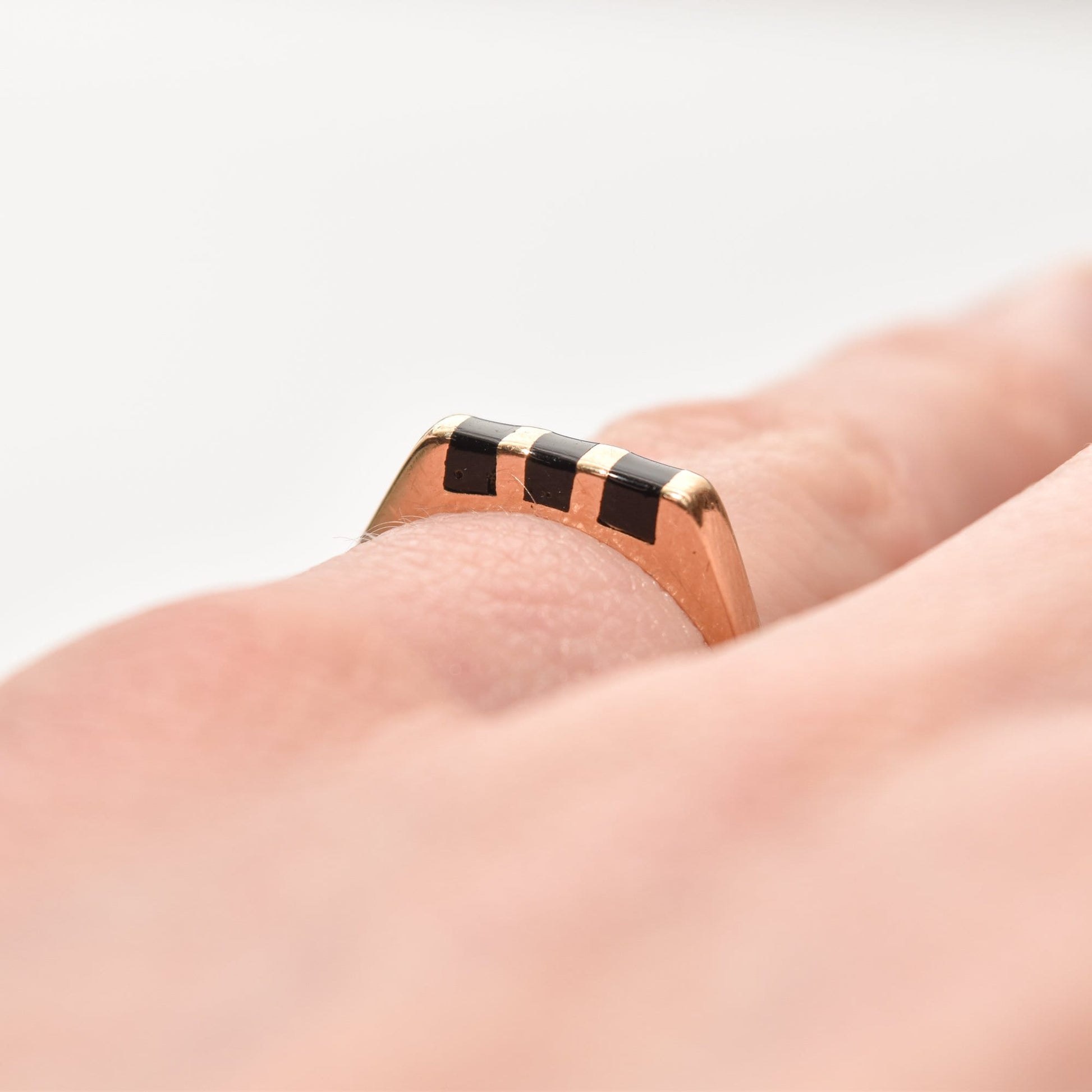 Minimalist 14K black onyx inlay ring on finger, striped yellow gold stacking ring, size 5.5 US, close-up display.
