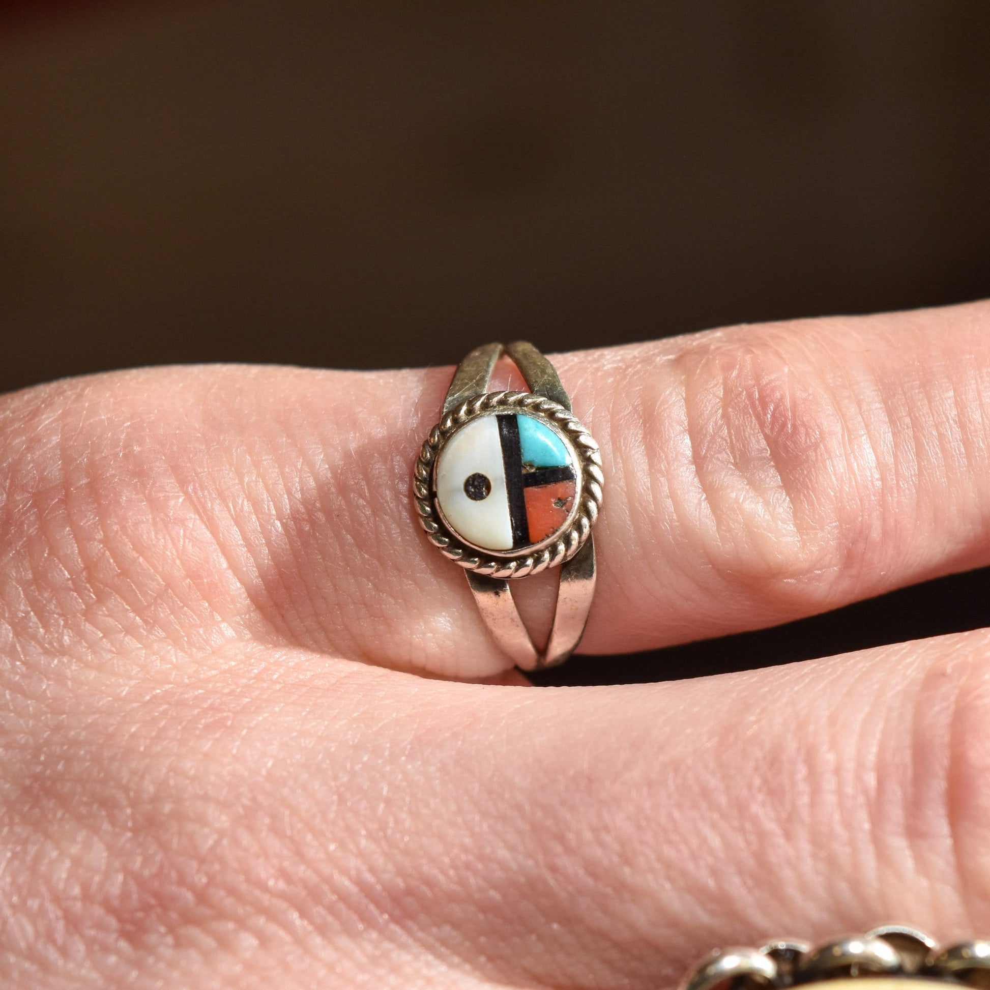 Sterling silver Little Zuni sun face ring with inlaid multicolor stones on finger, Native American jewelry, size 5.25 US, close-up view for stacking ring.