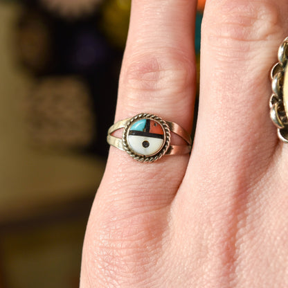 Close-up of a Little Zuni Sun Face Ring in sterling silver on a finger, showcasing inlaid Native American design, for size 5.25 US, ideal for stacking jewelry.