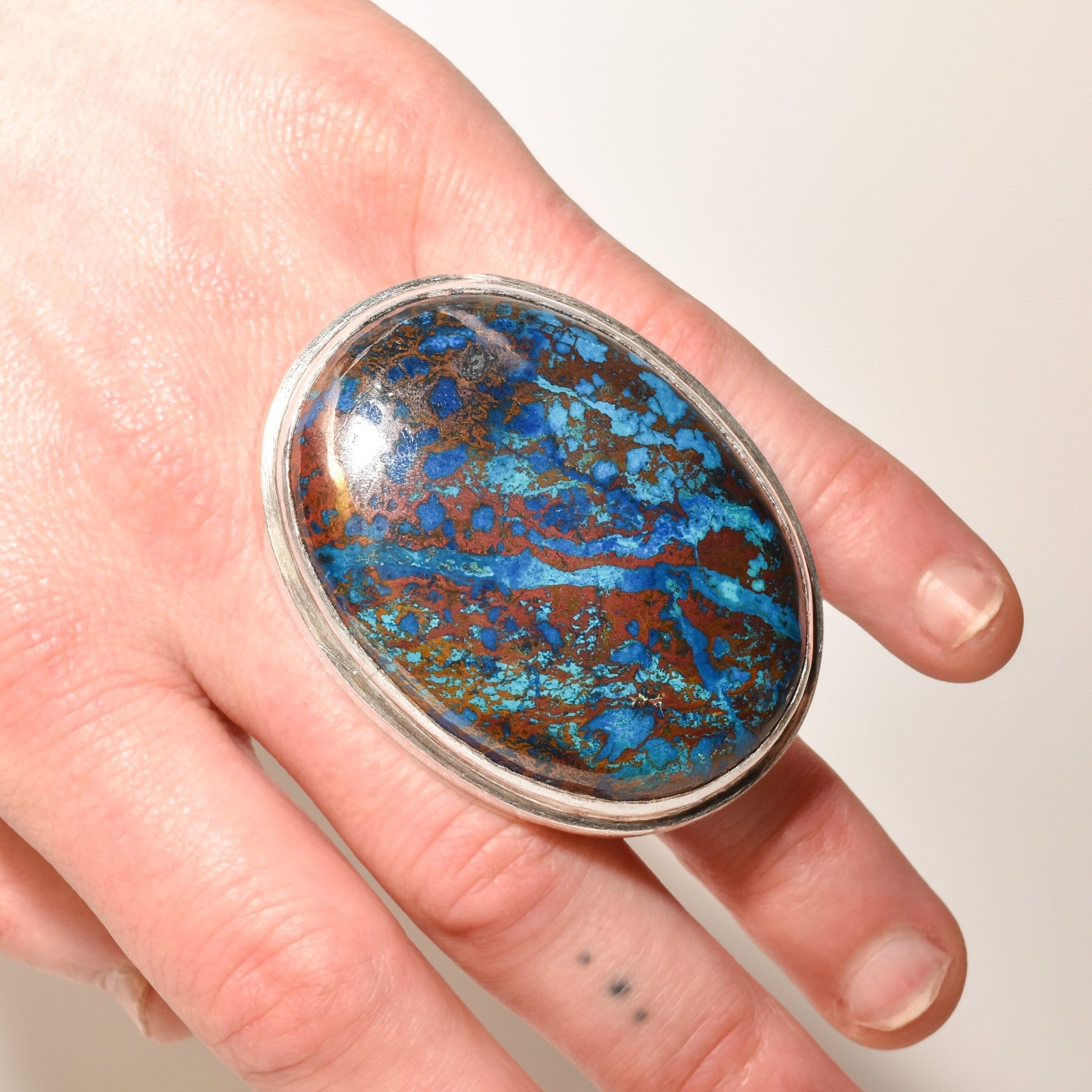 Huge sterling silver cabochon statement ring with chunky blue matrix gemstone on a hand, size 7 3/4 US.