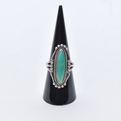 Native American sterling silver turquoise marquise ring displayed on black cone, southwestern jewelry, size 8 US.