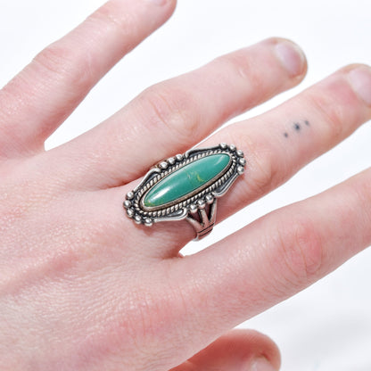Native American sterling silver turquoise marquise ring on a hand, Southwestern jewelry size 8 US, showcasing intricate design details.