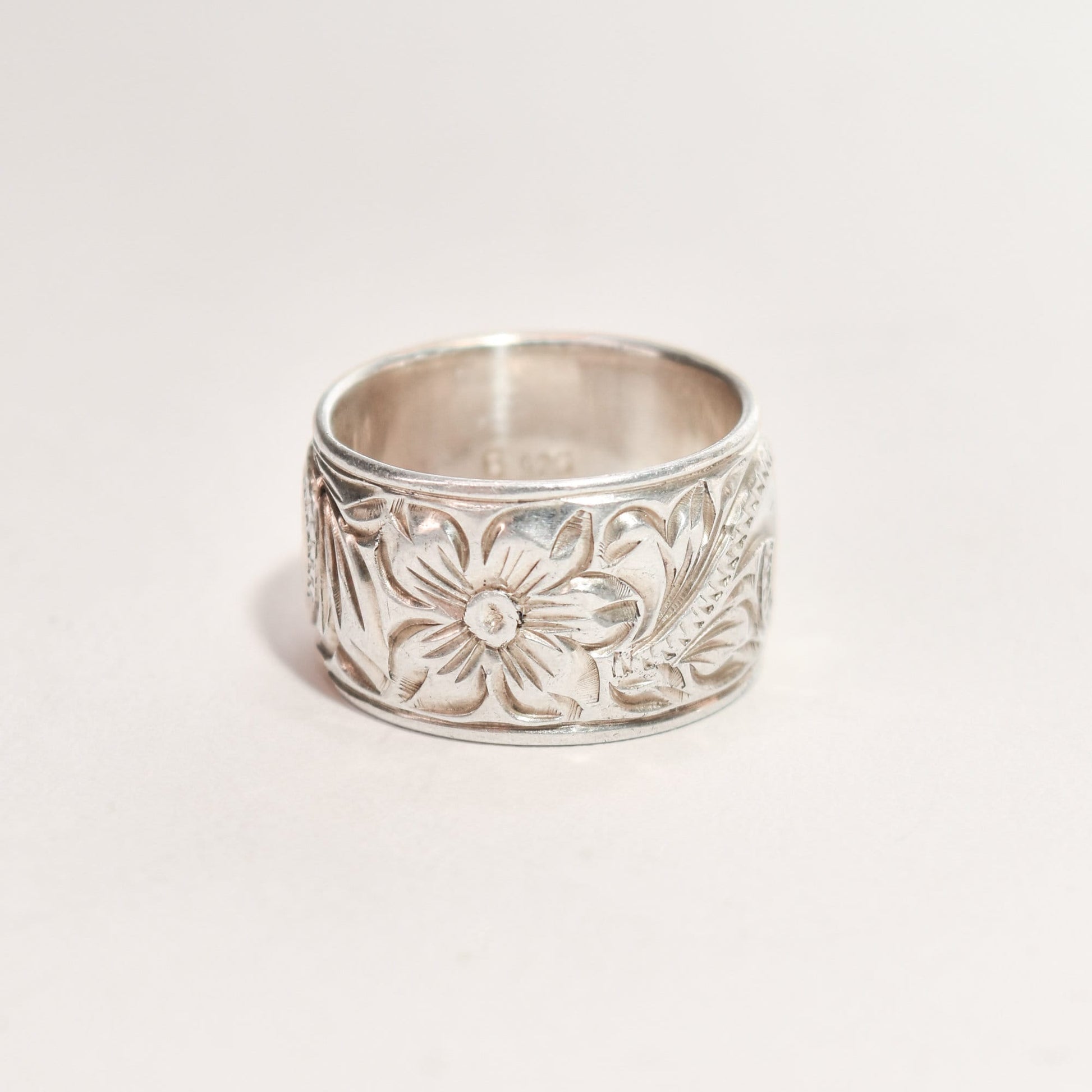 Floral-engraved sterling silver band ring, 11.5mm wide with Art Nouveau revival pattern, size 6 US, displayed on a neutral background.