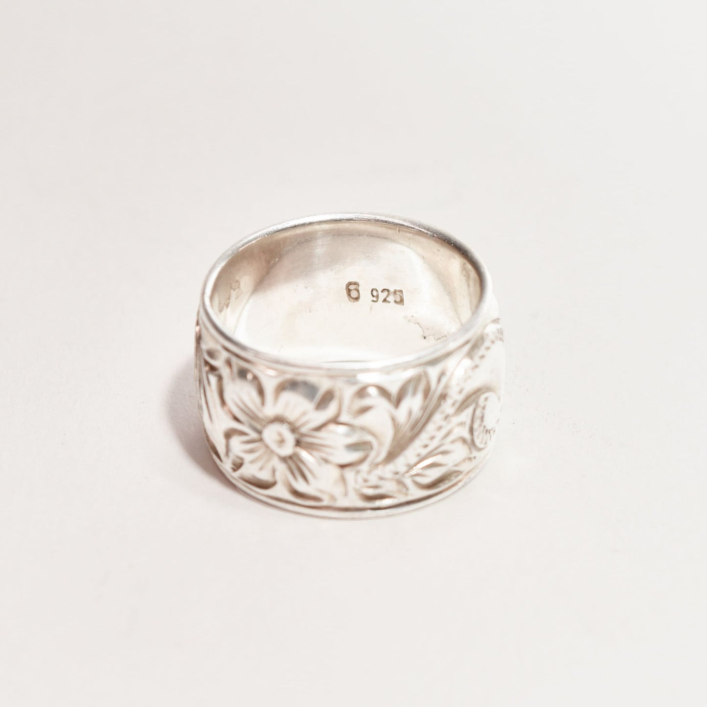 Floral engraved sterling silver band ring, 11.5mm wide with Art Nouveau revival style, showing size 6 US hallmark on inner surface against a white background.