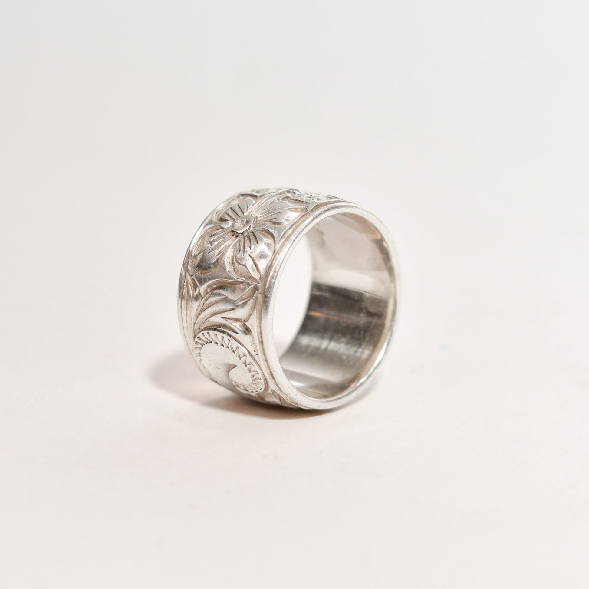 Alt text: Sterling silver band ring with floral engraving, 11.5mm wide, reflecting Art Nouveau style, size 6 US, on a neutral background.