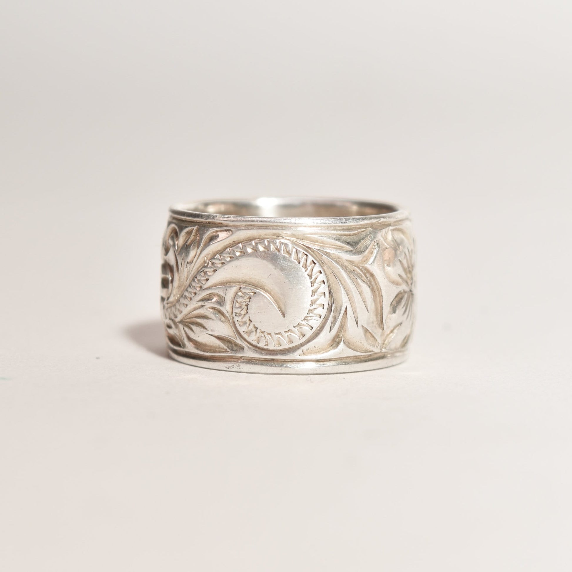 Floral engraved sterling silver band ring, 11.5mm wide with Art Nouveau revival style design, size 6 US, showcased on a neutral background.