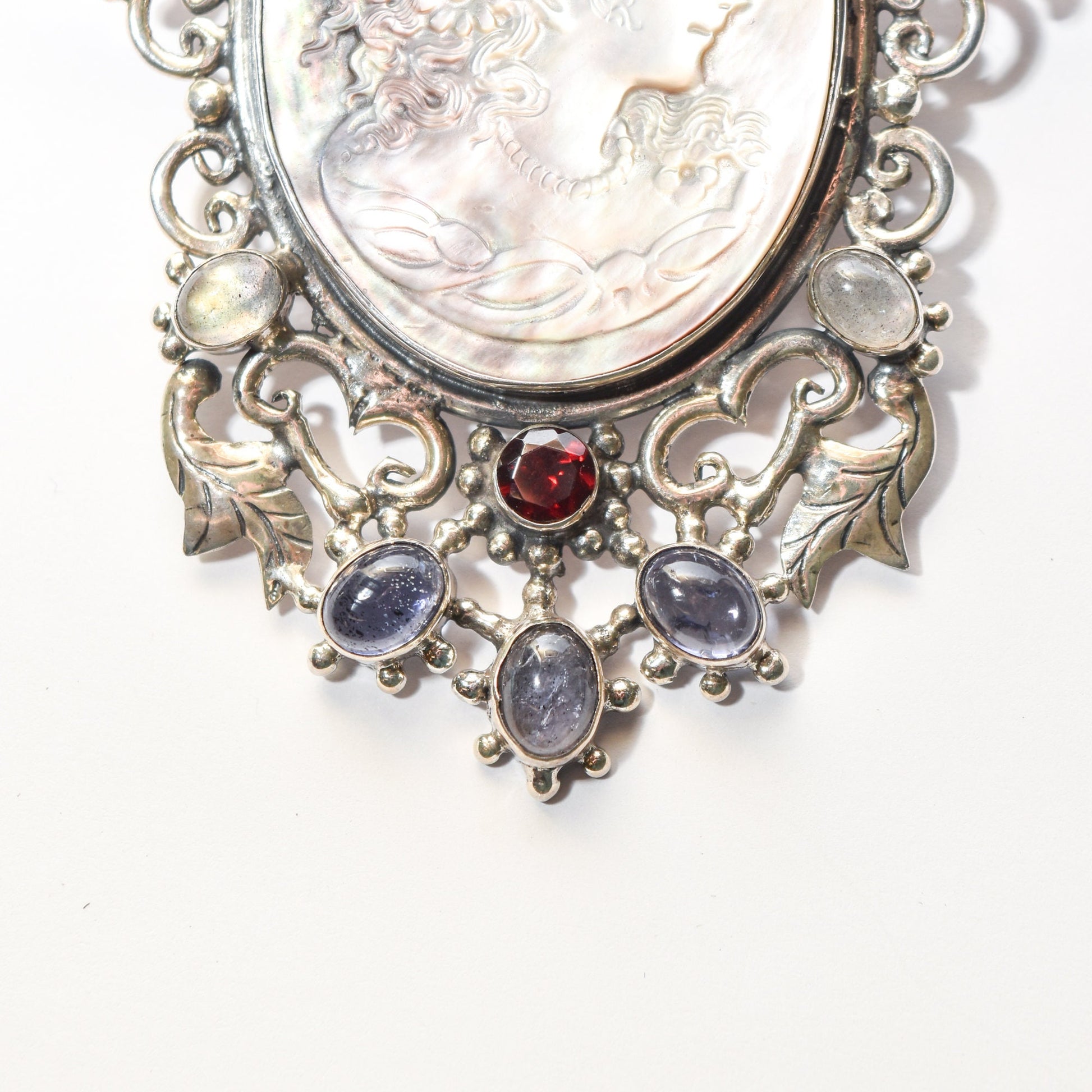 Victorian style sterling silver cameo pendant brooch with ornate multi-stone design featuring red gem centerpiece and dangling oval stones, 4 inches long.