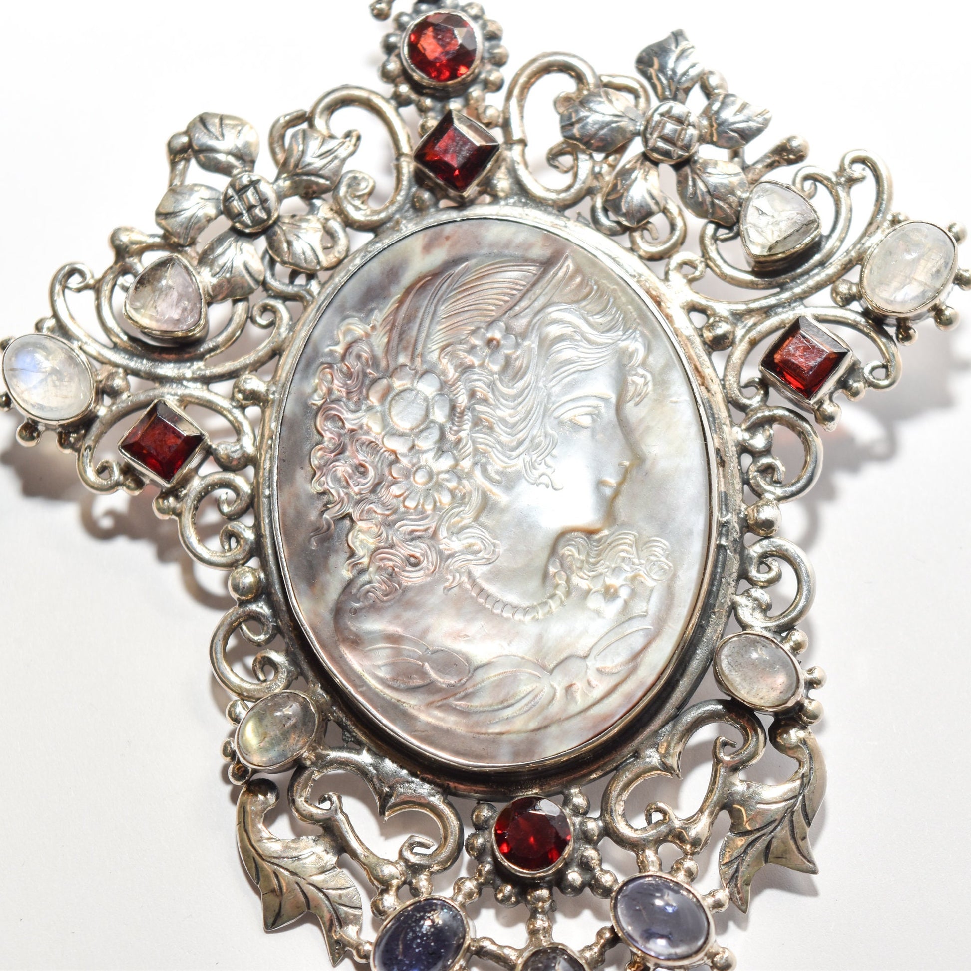 Victorian style sterling silver cameo pendant brooch with ornate multi-stone design, featuring red and white gemstones, 4 inches long.
