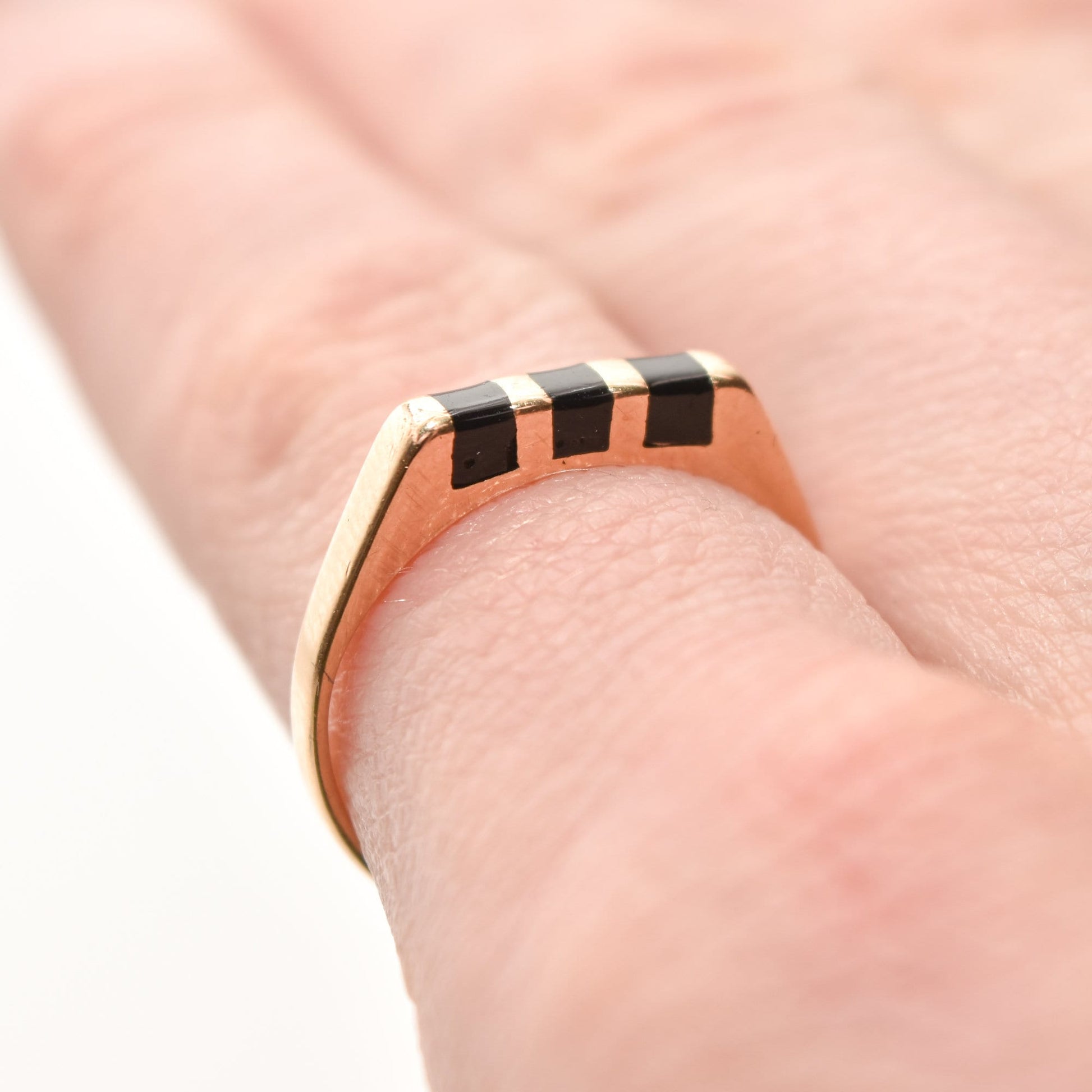 Minimalist 14K yellow gold stacking ring with black onyx inlay on a finger, size 5.5 US.
