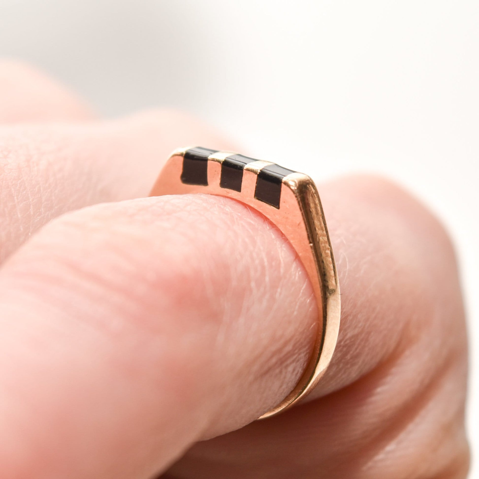 Minimalist 14K black onyx inlay ring on finger, striped yellow gold stacking ring, size 5.5 US, close-up view.
