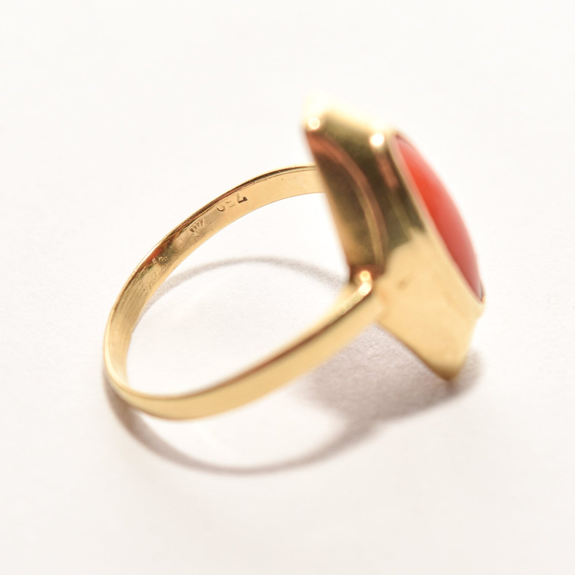 Estate 18K yellow gold ring with marquise-cut red coral, size 5.25 US, on a white background.