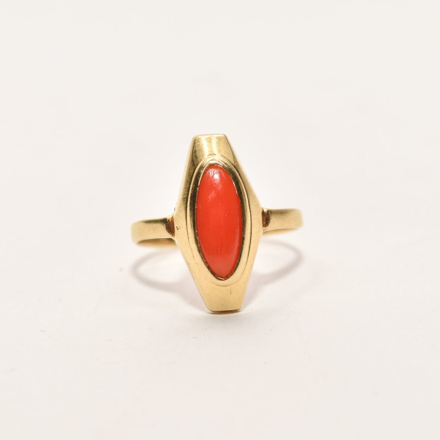 Estate 18K yellow gold ring featuring marquise-cut red coral, size 5.25 US, displayed on a white background.