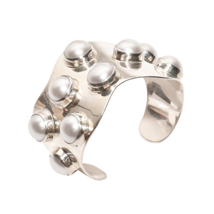 Alt text: "TAXCO modernist sterling silver mabe pearl cuff bracelet with a wide wavy design, showcasing statement style, size 5.75 inches, displayed against a white background.