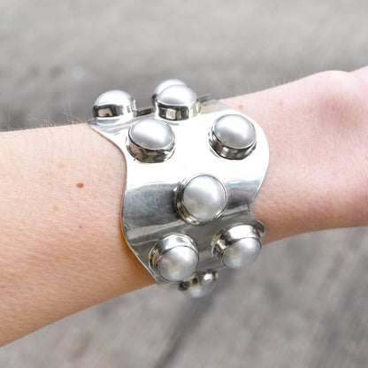 Alt text: "TAXCO Modernist Sterling Silver Mabe Pearl Cuff Bracelet on wrist, featuring a wide wavy design with multiple pearl accents, measuring 5.75 inches, showcasing elegant statement jewelry style.