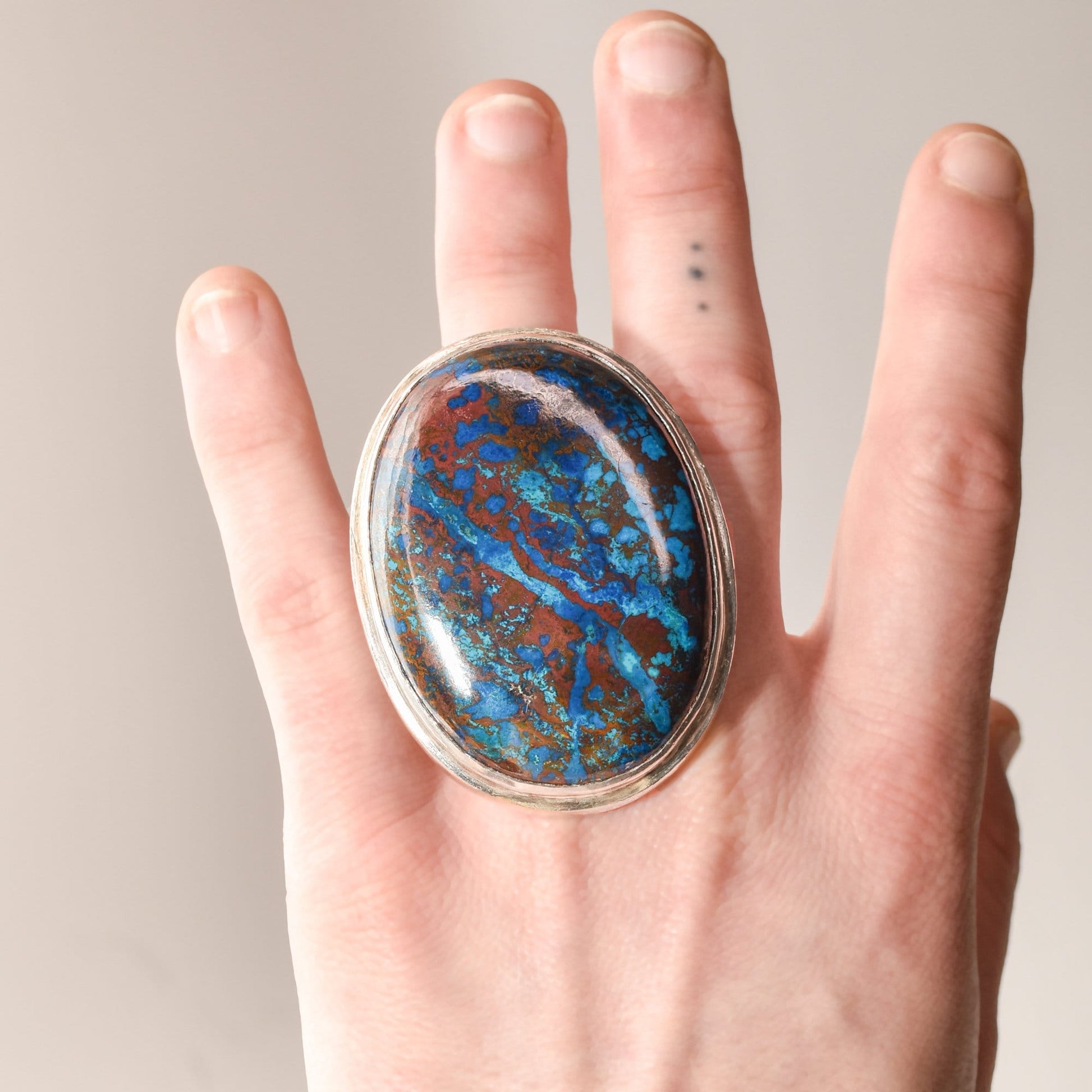 Huge sterling silver ring with blue matrix cabochon gemstone on a person's hand, statement jewelry size 7 3/4 US.