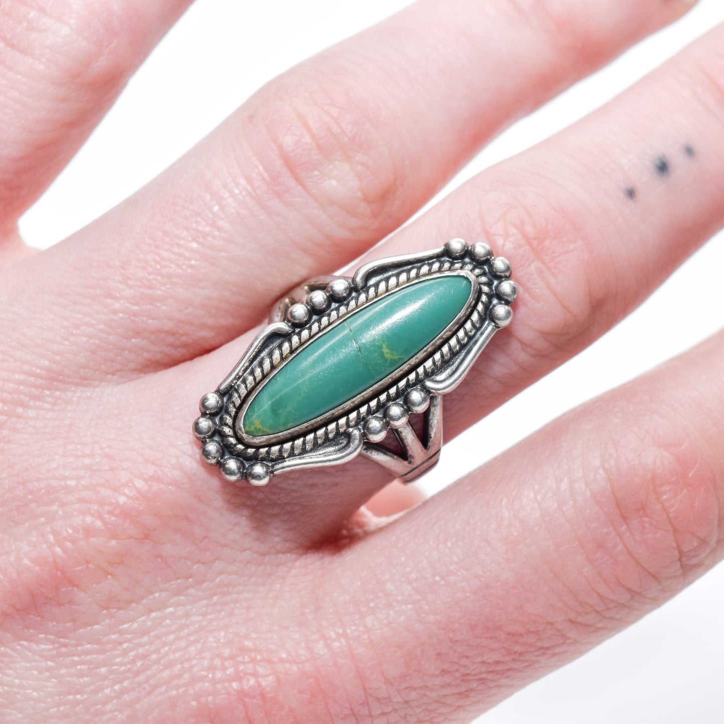 Native American sterling silver turquoise marquise ring on finger, Southwestern jewelry, size 8 US, with intricate metalwork detail.