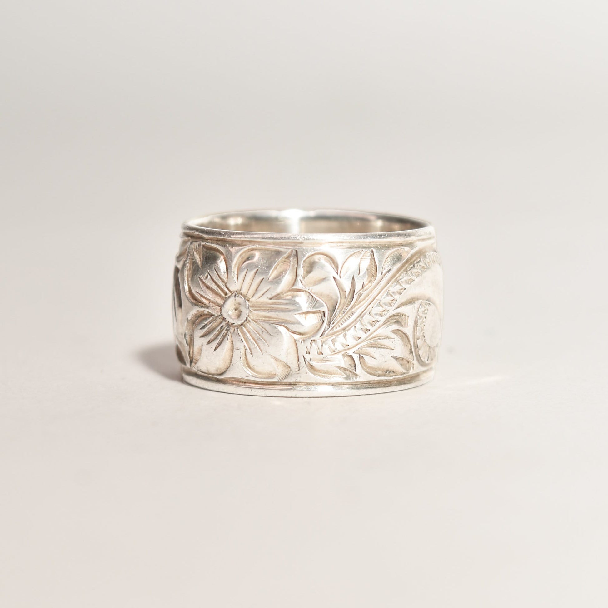 Floral engraved sterling silver band ring, 11.5mm wide, Art Nouveau revival style, size 6 US, displayed on a neutral background.